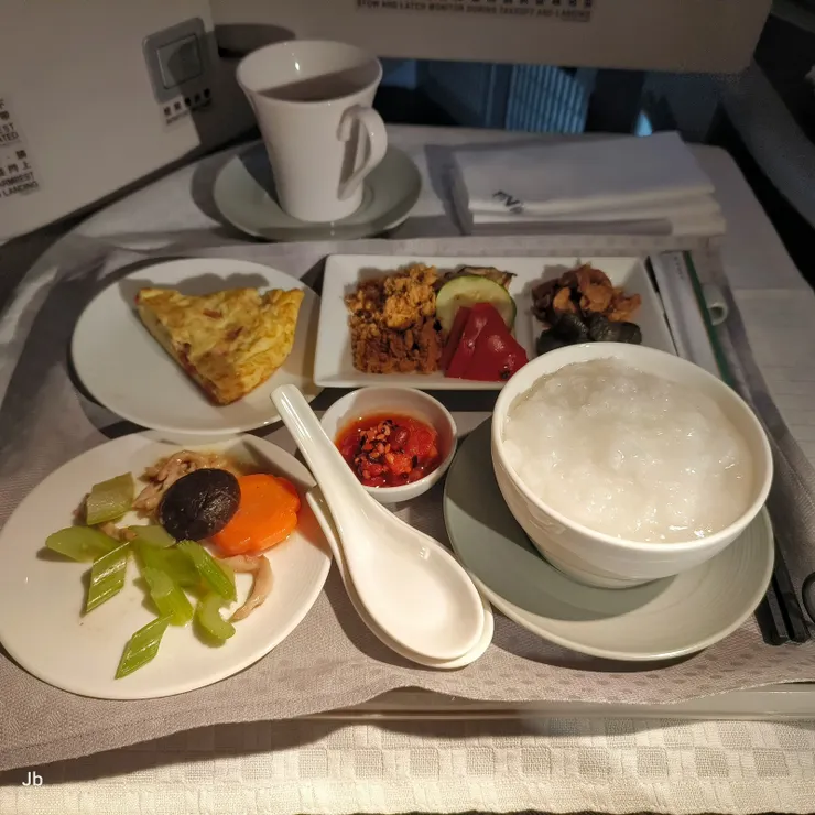 【吃吃喝喝躺平睡漫讀淵明評傳，十餘小時飛行砸錢換得不疲累！航程剩約2小時，起床吃個清粥小菜。】