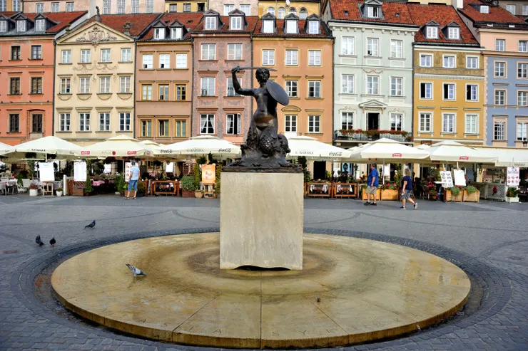 【美人魚仍在集市廣場中心護守！廣場中央引人注目的美人魚雕像，右手高舉利劍，左手持盾，象徵著守衛城市的決心與勇氣。美人魚自 16 世紀起即出現在華沙的盾徽上，是城市的標誌。】
