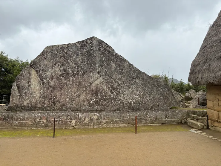 當時就是站在這塊聖石旁穿雨衣