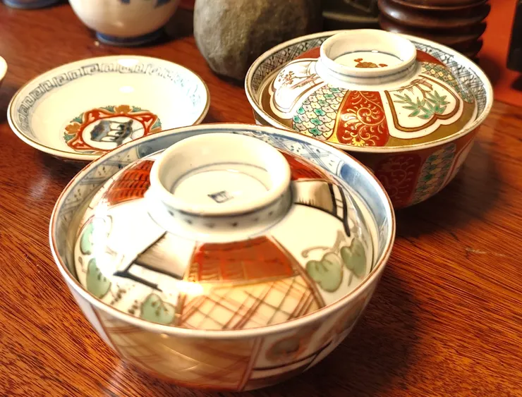 赤繪五彩：在燒好的白瓷上，用紅、綠、黃、藍等顏料繪畫，再經低溫二次燒成。碗身與蓋子上的花卉、紋樣，色彩鮮豔，層次豐富