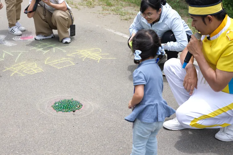 香蕉哥哥正在為努力想用鐵砂珠擊中彈珠得分的妹妹加油