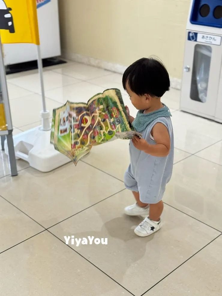 到了日本，寶寶有模有樣地看起了景點介紹手冊