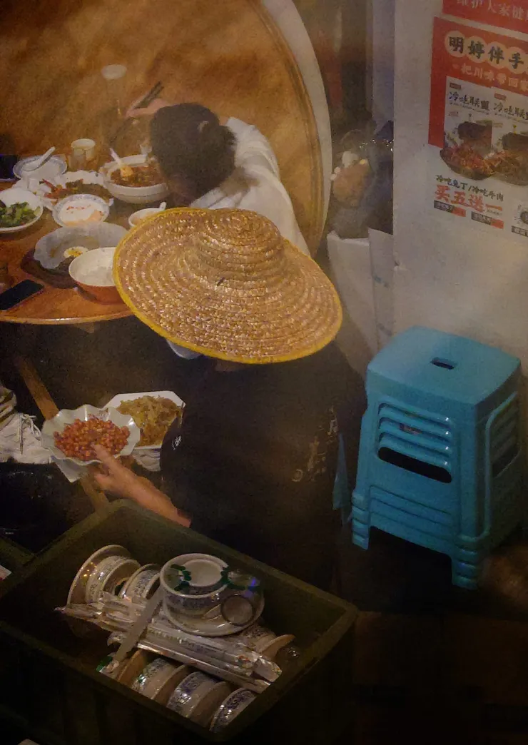 因為下雨，服務人員戴著斗笠，過街送菜