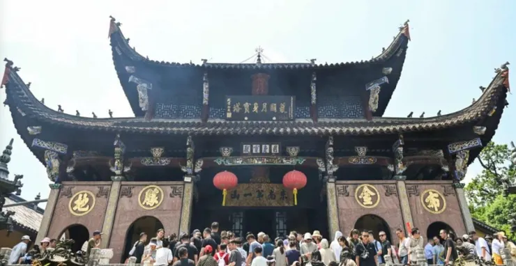 肉身宮的正面建築，雄偉的屋頂裝飾著精美的雕刻和顯眼的紅燈籠，前方擠滿了來訪的遊客，氣氛熱鬧非凡。