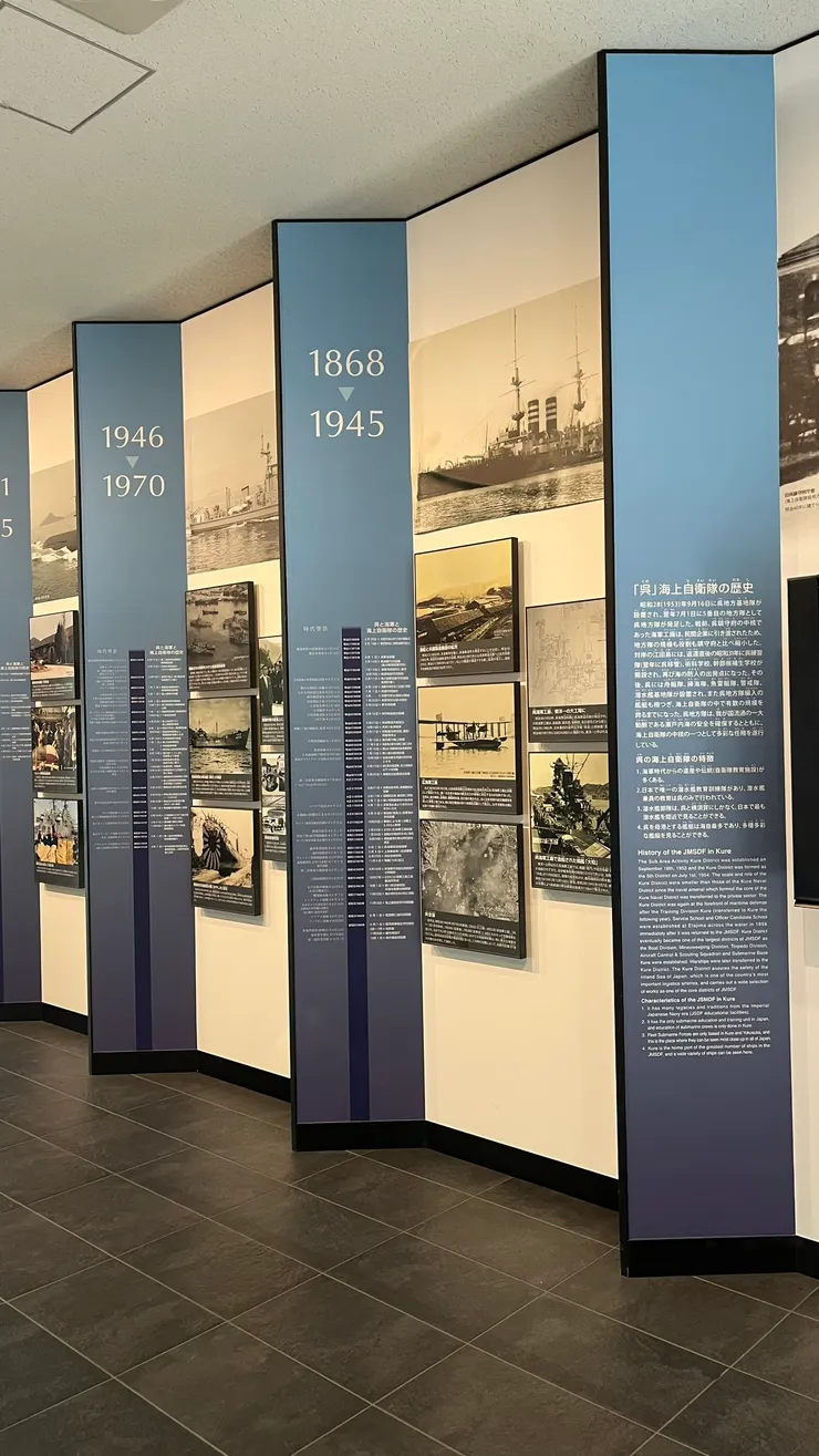 牆面設計以垂直年份柱為視覺節點，搭配老照片、港灣空拍、艦艇影像與詳盡文字說明，讓人能沿著時間軸一步步理解吳港的角色轉變。