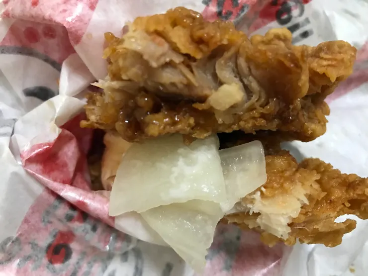 兩片炸雞腿吃得很膩，夾醃蘿蔔片解膩才吃完