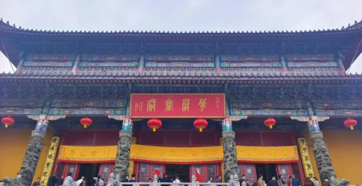 旃檀林的正面，紅色匾額上寫著「開光大吉」，黃色的大門口掛著紅燈籠，旁邊的雕像與細緻的建築細節令人印象深刻。