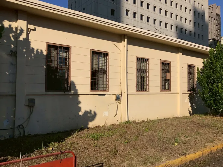 平面的屋頂、突出的屋簷，外露的梁柱系統搭配長條型窗戶和淺淺的窗台。窗戶高度範圍的牆面，施以溝縫處理。（2021年。筆者友人提供）