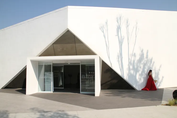 身著紅色婚紗的新娘正於館外拍攝婚紗照。