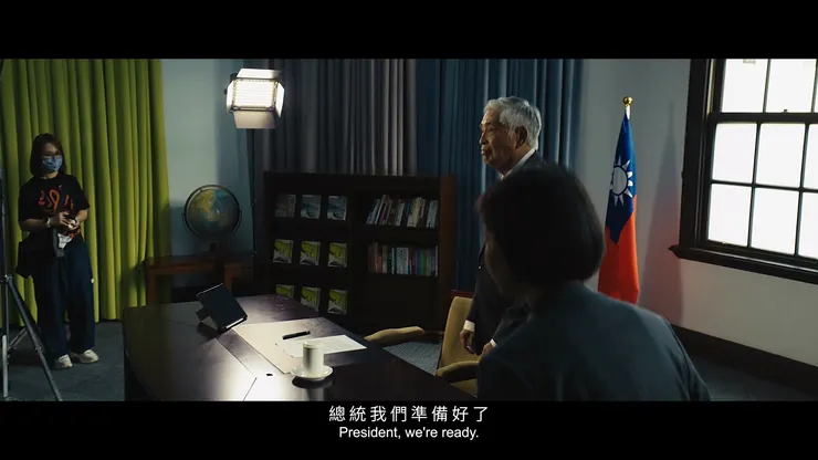 在畫面右側、背對我們的就是即將接任的在野黨主席王明芳，前導片中比較少描述到。