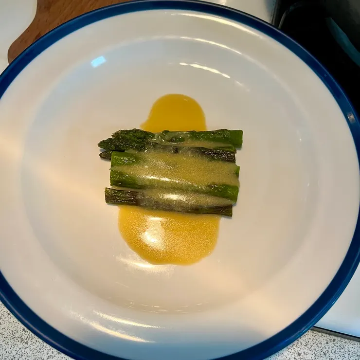 這是有加蛋黃的版本，在舖底的煎蘆筍上先淋醬汁