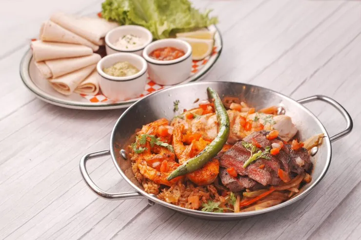 ▲「墨西哥法士達」適合2至3人分享,集結鮮蝦、碳烤牛肉與香煎雞肉三種主食,搭配洋蔥、彩椒與香飯,附上6片餅皮與多款醬料,可自由包餡。