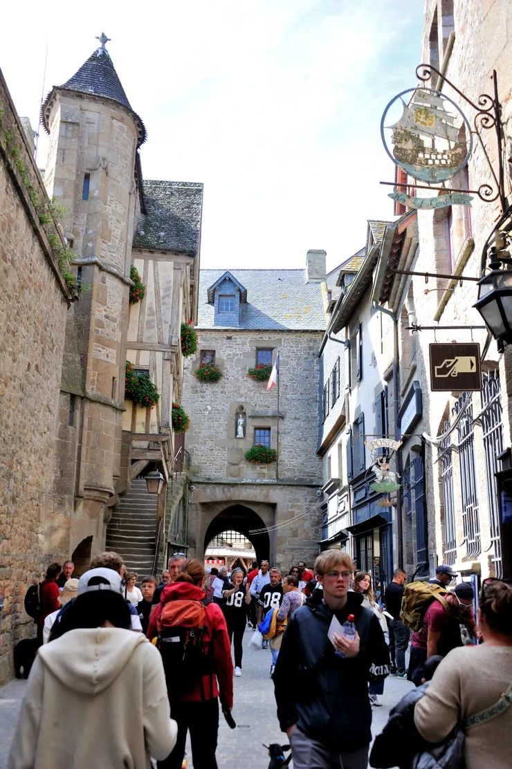 【聖米歇爾山的大街(Grande Rue)，為主要商店街，遊人熙來攘往，兩旁建築保持中世紀風格，多為石造。準備出城了！】