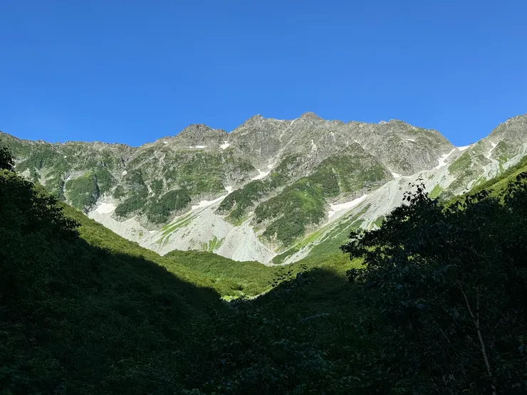 涸澤Hütte 和涸澤小屋在底下綠色山頭的上緣，穗高岳山莊在右上鞍部雪溪的上緣。
