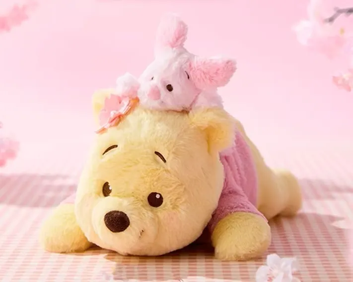 圖說：MINISO南紡正櫃首波主打系列之一「櫻花祭維尼趴姿公仔」，維尼與小豬舒適柔順的絨毛外觀可愛滿點，引爆粉絲收藏熱潮。（資料來源：MINISO）