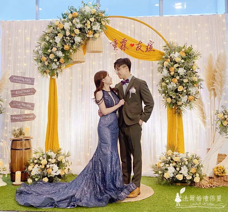 幸福檸檬黃婚禮佈置 @ 台南亞果薈 安妃屈蒂餐廳  在台南的海風與陽光中，亞果薈 安妃屈蒂餐廳見證了無數浪漫時刻。這場以 **「幸福檸檬黃」**為主題的婚禮佈置，運用溫暖明亮的檸檬黃色調，搭配歐式花環與羽毛芒草，營造出陽光般的幸福氛圍。  金黃色的拱門，點綴著飽滿的白玫瑰與香檳玫瑰，配上木桶、燈串與鄉村風擺飾，讓每個角落都成為新人與賓客的拍照打卡點。  「幸福檸檬黃」不只是婚禮顏色，更是一種情感的溫度——象徵喜悅、溫暖與甜蜜。每一次呈現都經過專業團隊的精準擺設，確保現場與範例一致，讓新人在籌備婚禮時更安心。