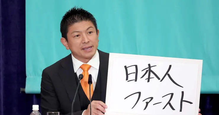 參政黨黨首神谷宗幣舉著「日本人優先」的手牌(圖片來源:産経ニュース)