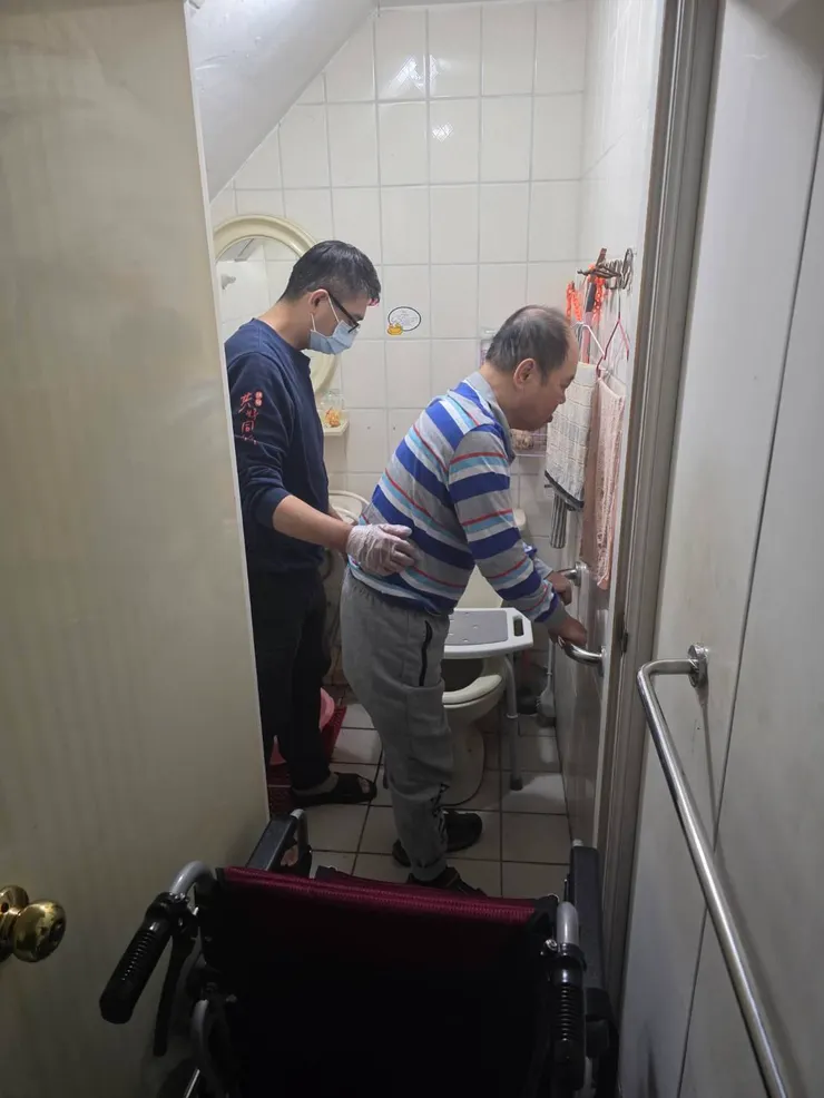 （圖說：胡偉晟協助使用者如廁。）