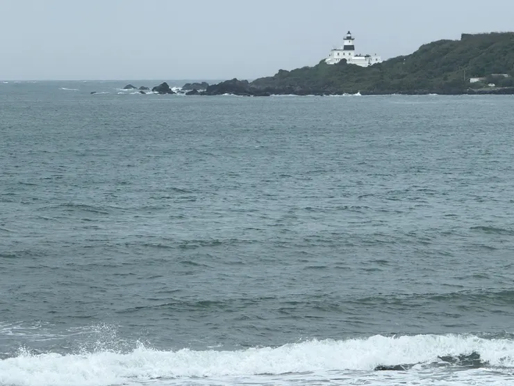 2025/11/22 泡芙店外的海景，黑白相間的燈塔是富貴角燈塔