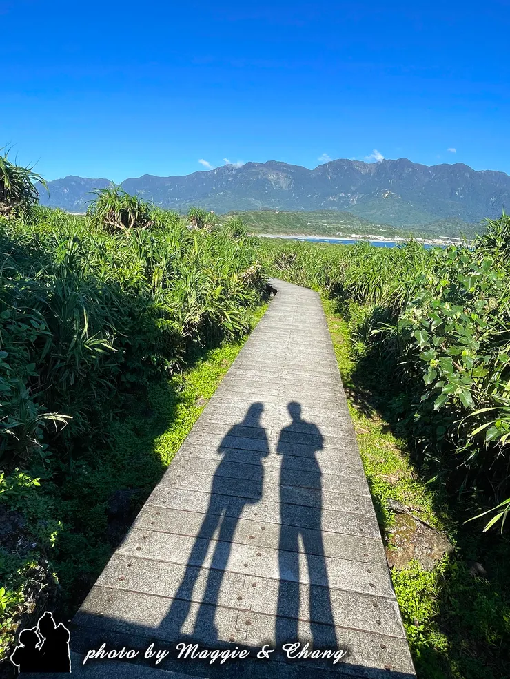 走在台東三仙台的秘境步道上，迎面而來的是無盡的藍天與綿延的海岸山脈。陽光灑落，投下我們並肩而行的身影，映在木棧道上，彷彿記錄下旅途中最簡單卻最珍貴的片刻。這裡沒有過多的喧囂，只有微風、綠意與山海交織的寧靜，讓人不自覺放慢腳步，用心感受眼前的純淨與美好。