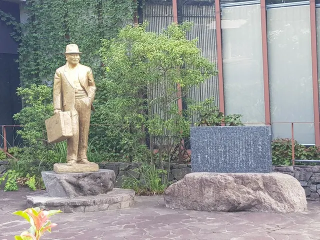 寅次郎會館庭院內的寅次郎雕塑以及說明石碑