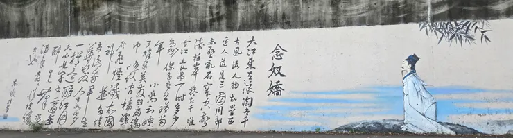 「念奴嬌.赤壁懷古」—— 艋舺的「搶灘」與崛起 第二面牆詩的豪放派巨作: 「大江東去,浪淘盡,千古風流人物... 亂石崩雲,驚濤拍岸,捲起千堆雪。江山如畫,一時多少豪傑。」這首詞放在這裡,簡直是艋舺(萬華)崛起的最佳BGM!我們再次為東坡先生進行在地化翻譯:「大漢溪去,泥積盡,新莊風流商賈。淡水河邊,人道是,艋舺深水碼頭。驚濤拍岸,捲起千堆錢,商圈如畫,一時多少角頭(豪傑 )」 詩注: 當新莊因為水淺而衰退時,「大江」(淡水河與大漢溪、新店溪的交匯處)的優勢就顯現出來了。艋舺剛好位在這個黃金交會點,水位深、腹地廣,完美接手了新莊無法吃下的龐大貿易量。 於是,那些原本在新莊的「千古風流人物」(各大郊商、有錢大老闆),就像被歷史的浪潮推著走一樣,紛紛順流而下,把資金、貨物和夢想全部搬到了艋舺。