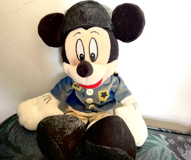 人生中第一個米奇娃娃。因為年代久遠，衣服有些退色，身體某些部分斑駁脫落了。