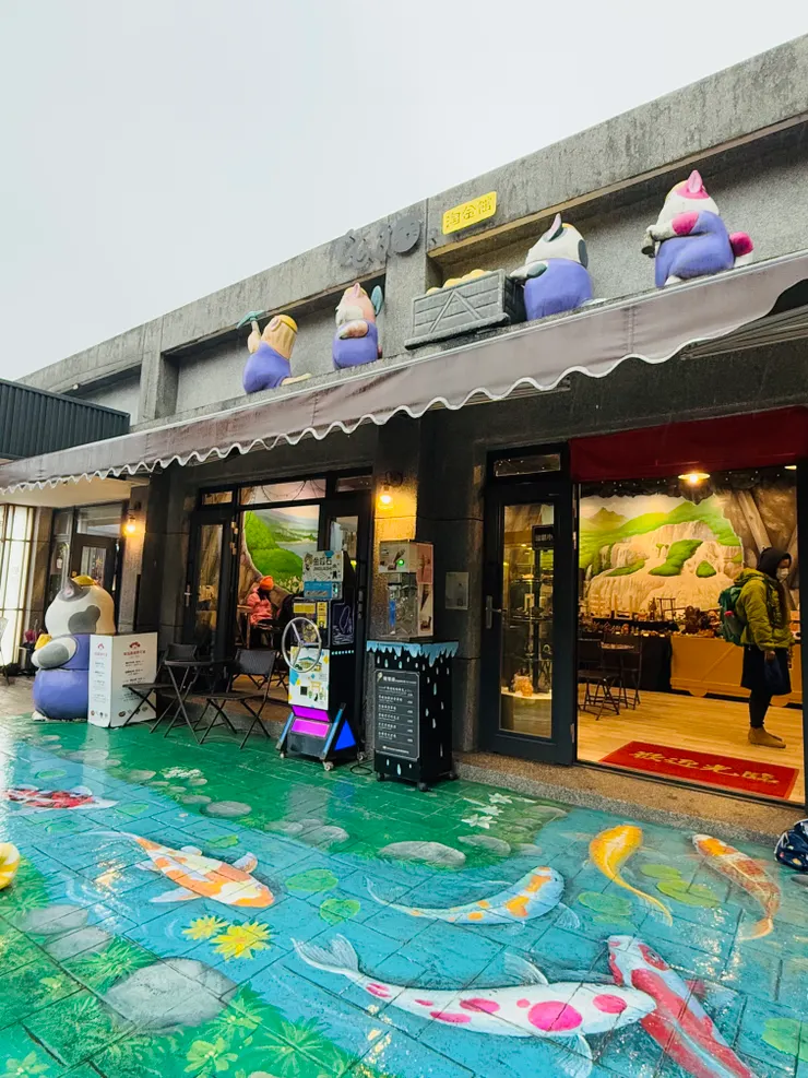 地上的彩繪圖案很逼真，加上下雨天的地面濕濕的，鯉魚真的像是快游進館內了。