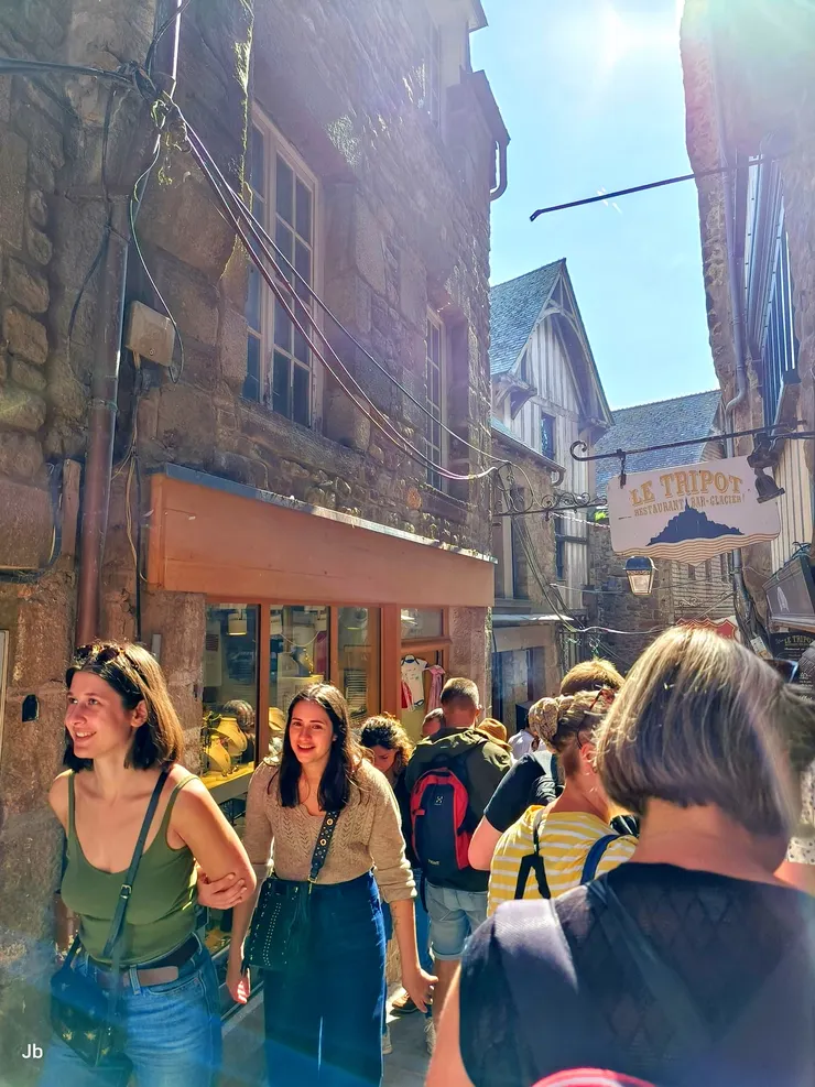 【聖米歇爾山的大街(Grande Rue)，為主要商店街，遊人熙來攘往，兩旁建築保持中世紀風格，多為石造。】