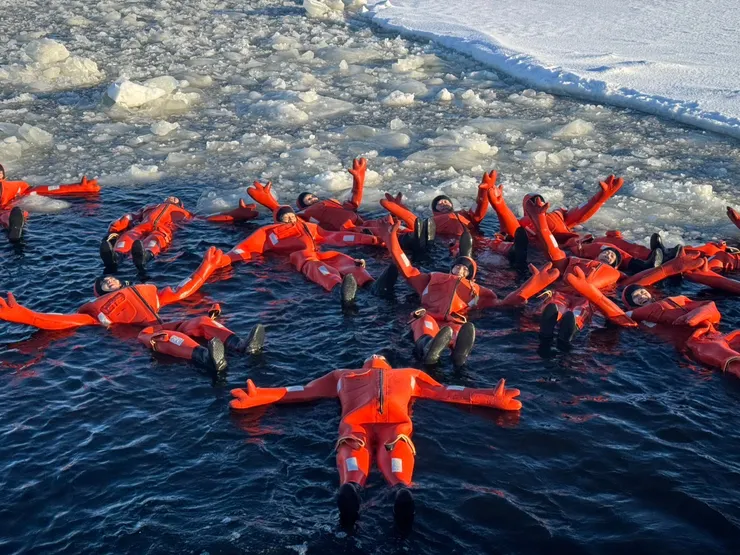 穿上紅色龍蝦裝,漂浮於碎冰間。 睜開眼,是灰藍天幕;閉上眼,是靜止時間的海。寒冷不再侵襲,只剩內心微微跳動,證明此刻是真實存在。「躺在冰之懷裡,好像世界靜止了,而我成了北極的一部分。」