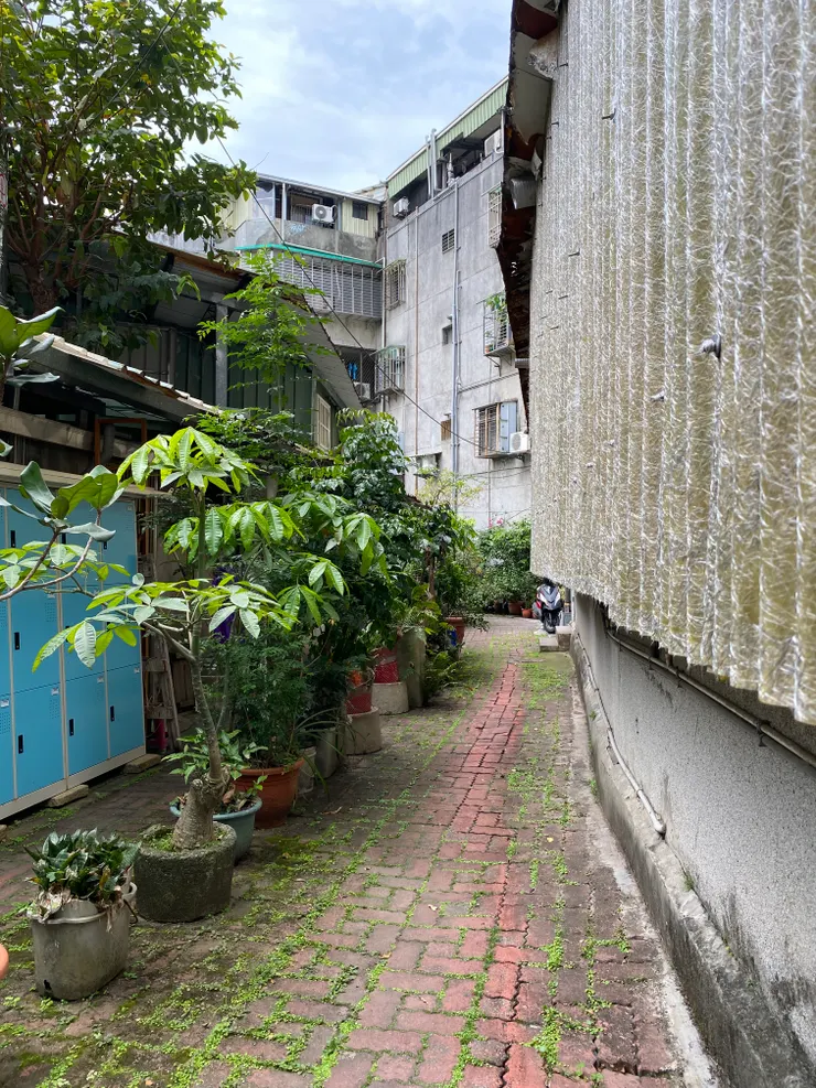 萬盛溪流過鐵皮屋與公寓之間的畸零地