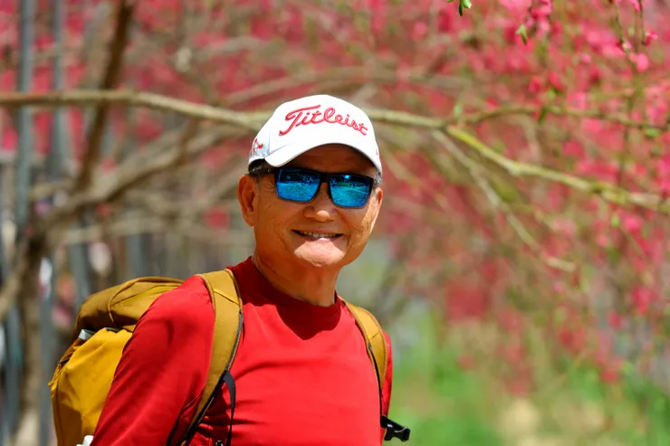 【桃花廊靠鐵桿撐起出乎意料,遠攝近拍費心截取最佳樣貌。背景的深紅是蟠桃花。】