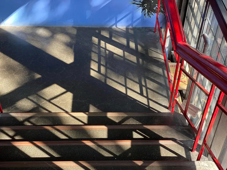 格子窗與樓梯在陽光的照射下，交織出美麗的光影