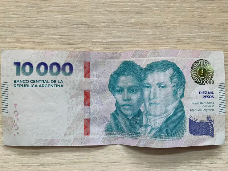2024年新發行的阿根廷10,000披索紙鈔，折合已不到10美元。正面有兩位主角，左側是參與獨立戰爭的女兵 María Remedios del Valle，右側是開國先賢之一 Manuel Belgrano