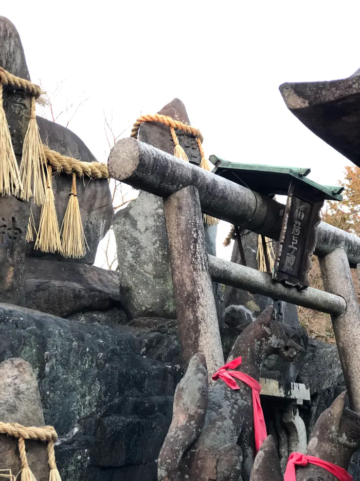 屋簷下的稻草繩靜靜垂落，這是神道的注連繩，微風拂過，草穗輕顫發出細細簌簌聲，標示神明所居的界線。