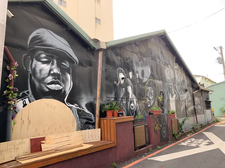 嘉義市巷弄間的壁畫，和後方鐵皮形成對比