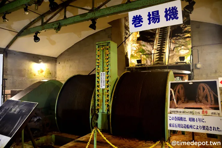 設於光榮立坑的捲揚機牽引著往返不同層坑道間的電梯,捲軸間的數字則對應到不同坑道的「樓層」。