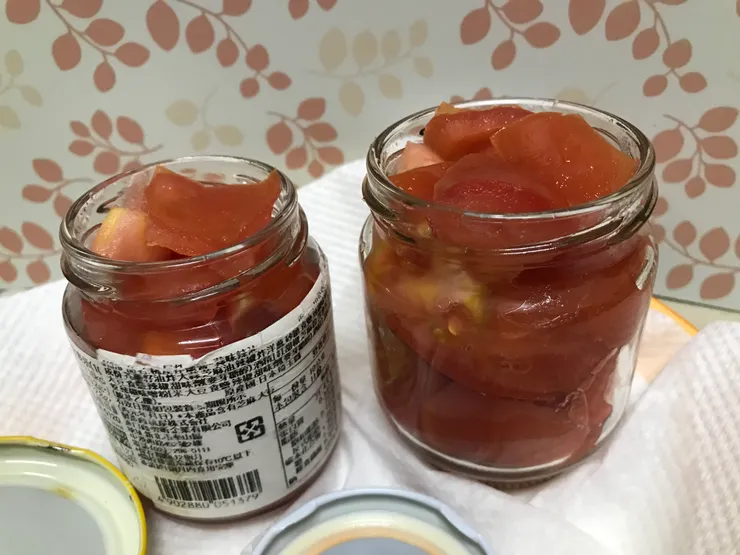 番茄切塊放入消毒後的玻璃瓶一大一小的番茄，小罐的裝了一顆大的番茄，說大顆其實大概直徑只有5、6公分左右。大顆的比較熟了所以裝罐的時候壓得進去，小顆的稍微硬一點