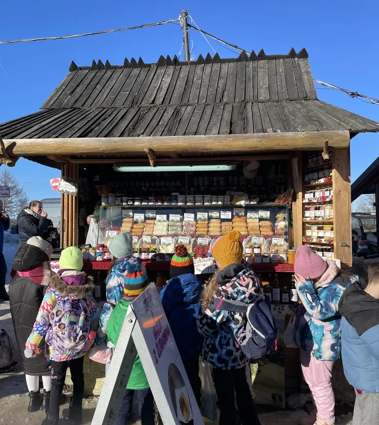 一群穿著滑雪裝的小孩聚在一起買起司超可愛
