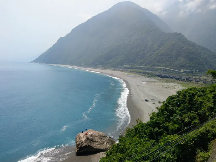 出隧道就是美麗的大海灣，有兩人在釣魚。