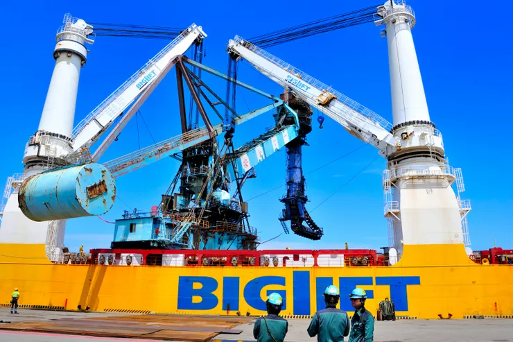 【海吊船如期抵達這過程難得一遇,看你順利離港心中大石總算落地!停在台中港31號碼頭的5號卸煤機。右下3人為原廠技師,他們要待到拆解完成才離開。】