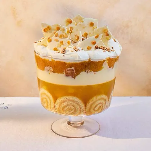 這款三色布丁是檸檬口味，三種不同層次的金黃色，奶油堆上擺放了小小塊的杏仁餅，形狀像一頂皇冠。