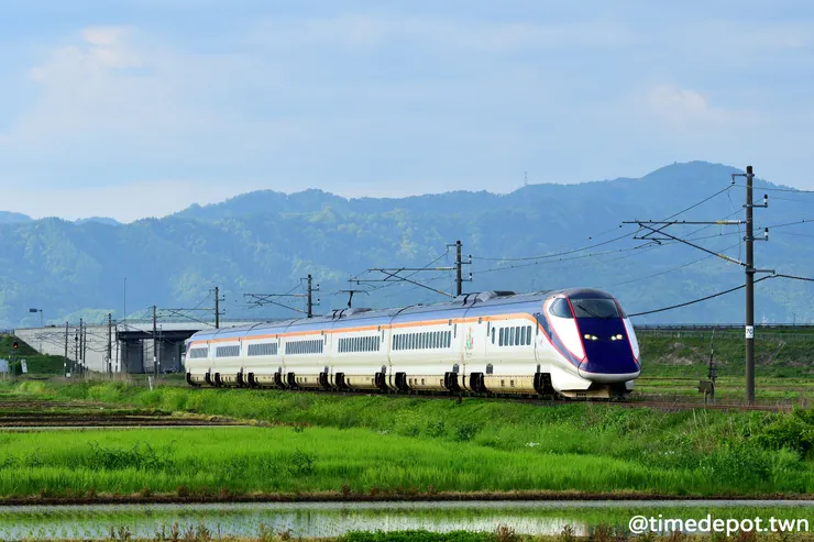 上行的E3系通過赤湯高畠間的田野