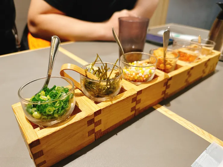 點餐後會先上六種配料：青蔥、海苔絲、小米香、炸蒜片、七味粉和鹽巴