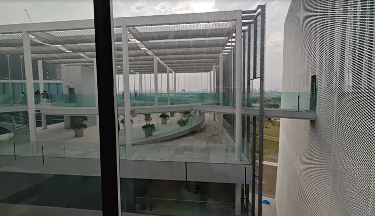 波浪紋外牆與多層玻璃廊道，綠美圖以幾何語言連結建築與自然