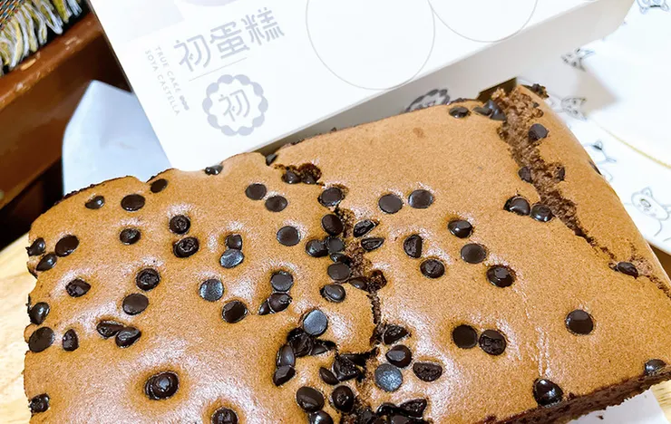 初蛋糕三峽老街店限量推出的巧克力口味全景，表面鋪滿香濃水滴巧克力豆，呈現深邃誘人的巧克力色澤，視覺感極強。