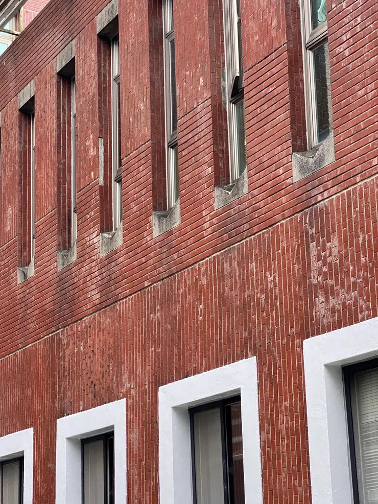 窗戶微收進立面內，窗框外上下有斬石子的雨遮和V字型漏水窗台