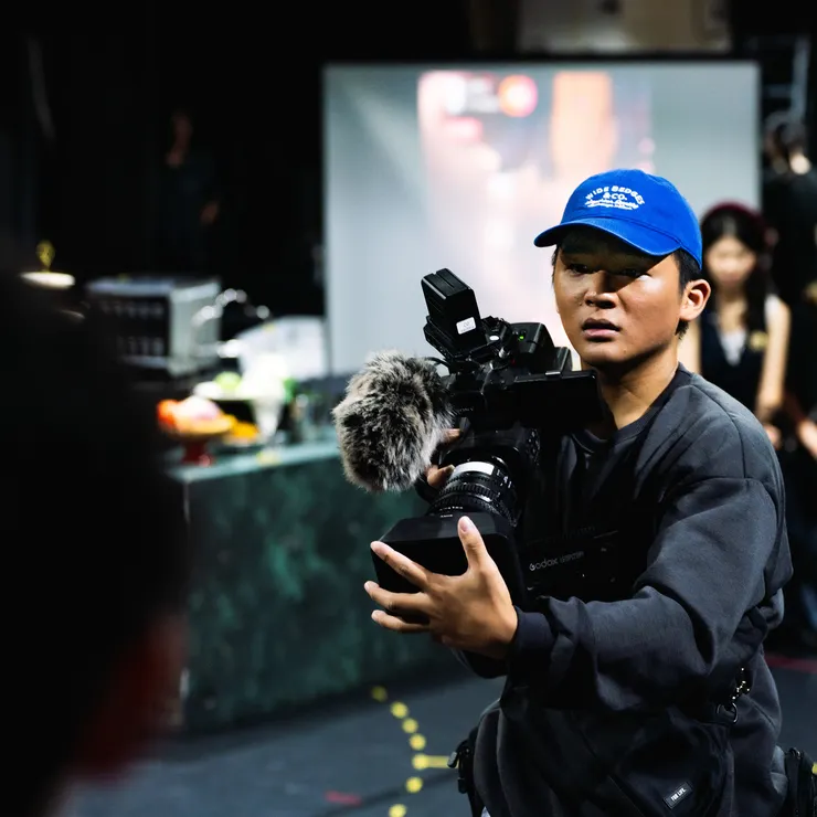 專業拍攝團隊捕捉演員表演身影,投影於舞臺牆面。(圖片來源:https://news.nsysu.edu.tw/p/406-1120-320898,r2910.php?Lang=zh-tw)