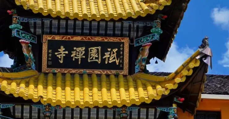 祇園寺的屋頂上，金色的瓦片和雕刻精美的屋脊與藍天相映成趣，匾額上寫著「禪禪國祀」字樣。