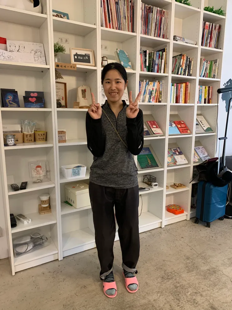 在青旅內的書架前，留下環島的最後一張手比天數照。